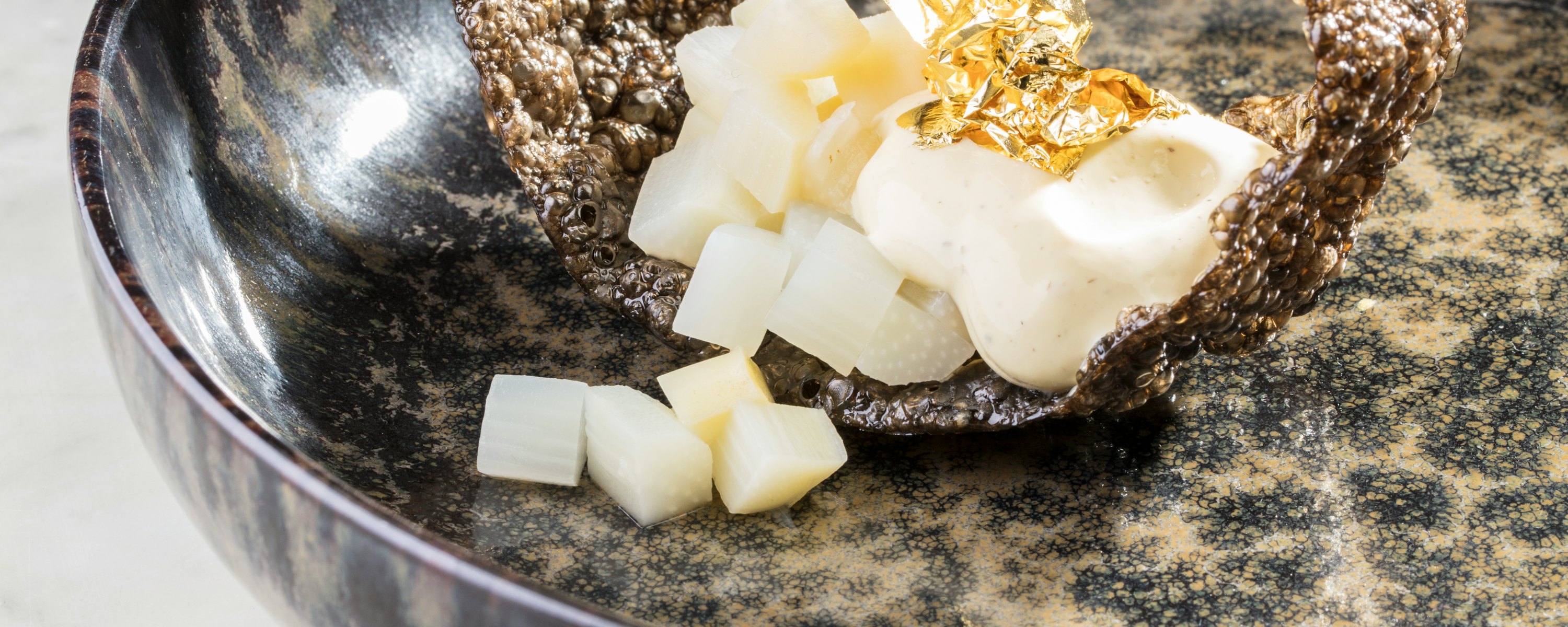 Zelfgemaakte tapioca kroepoek met asperge en bladgoud